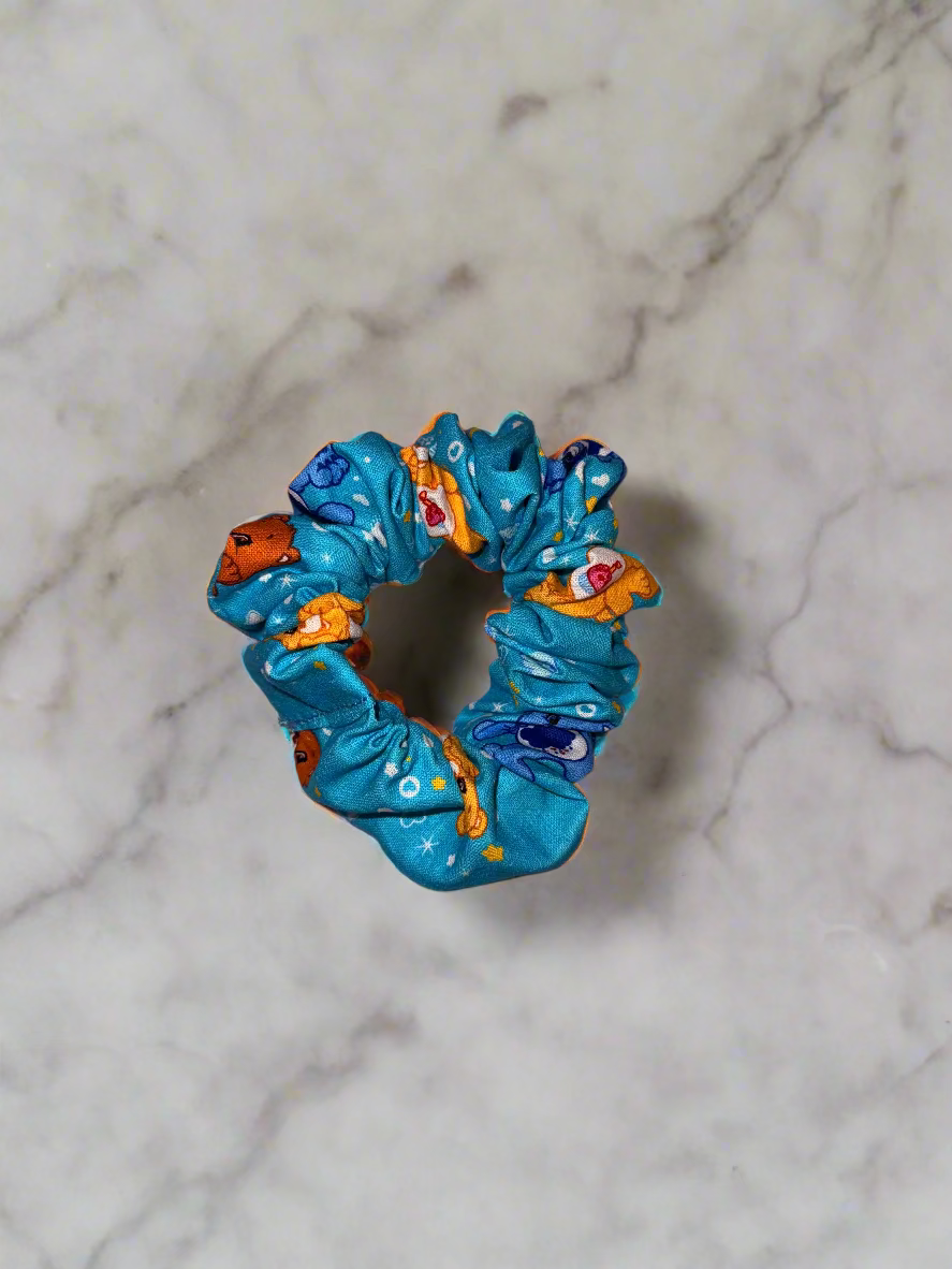 Blue scrunchie with colorful patterns on a pink fabric background
