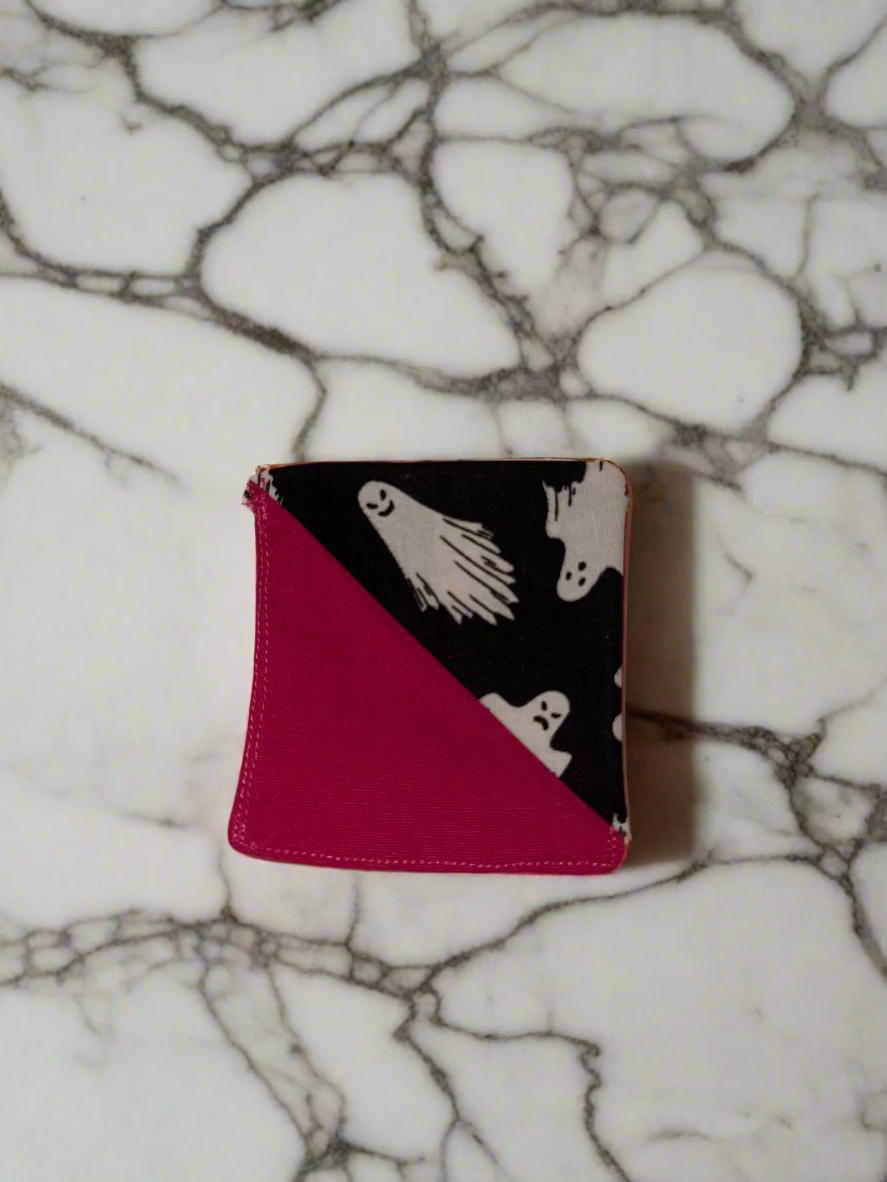 Corner Bookmark with ghost design on a pink background, lying on a beige surface.