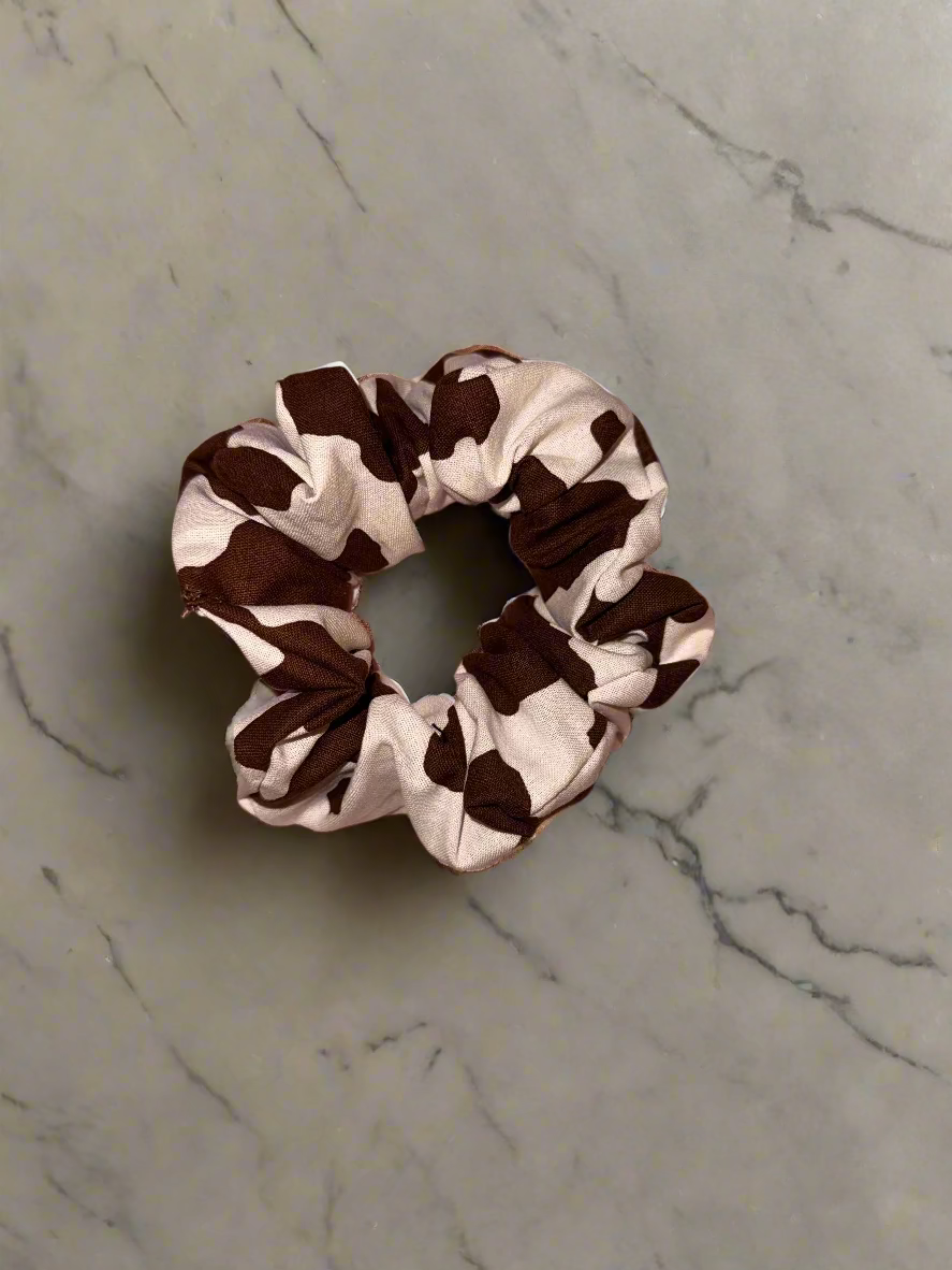 Brown and white patterned scrunchie on a marble surface