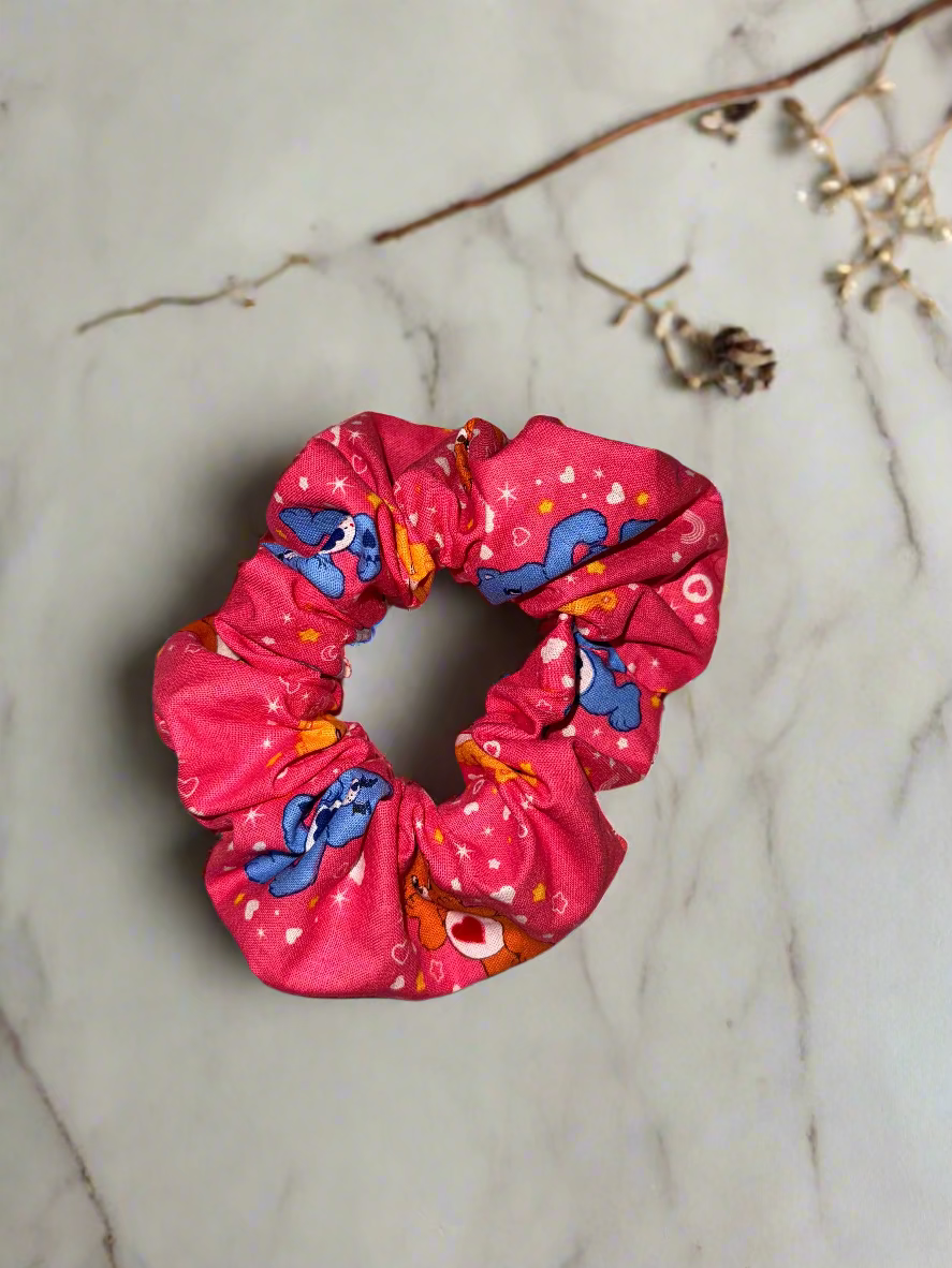 Pink scrunchie with colorful patterns on a marble surface