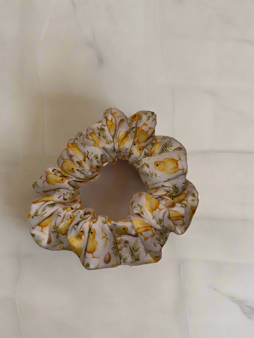 Scrunchie with chick pattern on a beige fabric background