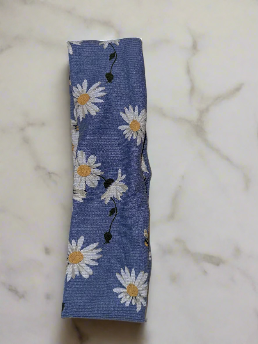Blue fabric strip with white daisy pattern on a beige surface